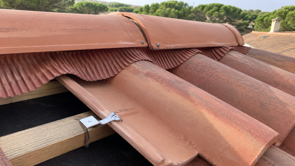 Détail de toiture en tuiles canal avec système de fixation et faîtage ventilé en zone ventée